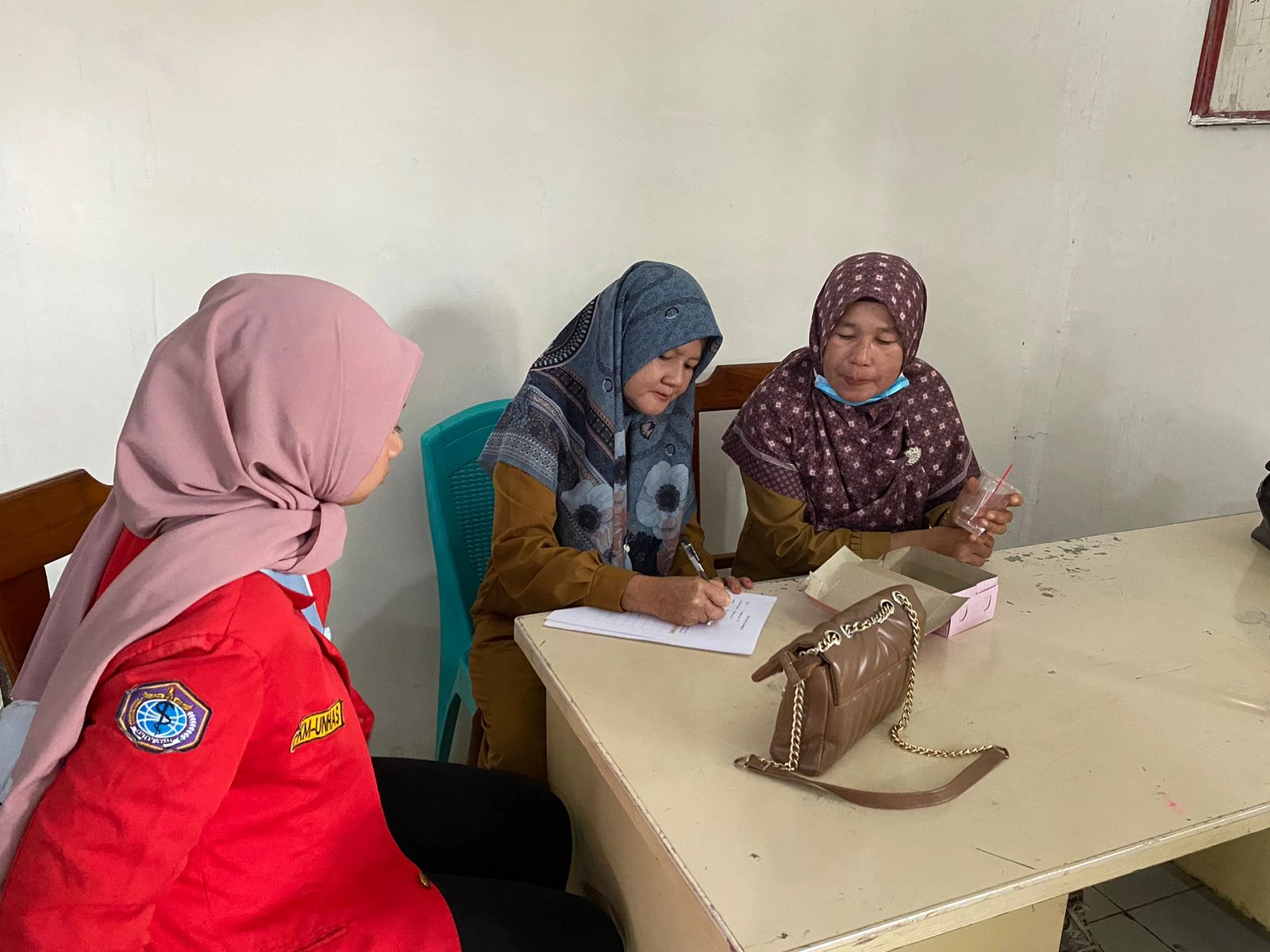 Salah satu anggota tim Posko 32 PBL III FKM Unhas (kiri) sedang melakukan pendataan atau wawancara sebagai bagian dari evaluasi program Ecobrick. Kegiatan ini bertujuan untuk meningkatkan kesadaran masyarakat dalam pengelolaan sampah plastik berkelanjutan di Kelurahan Tonrokassi Timur, Jeneponto. Kredit: FKM Unhas.